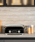 SMEG MGF01 Retro Countertop Electric Grill and Panini Press With Swappable Plates on kitchen counter with wooden boards.