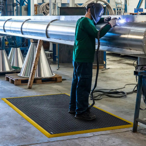 Welder using Diamond Flex Fire Retardant Rubber Anti Fatigue Mat For Welding Workstations Heavy Duty 40 By 64 Inch Industrial Floor Mat