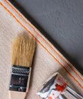 Stay Put Canvas Plus Drop Cloth 9 Ft By 12 Ft With Leak Resistant Protection showing edge, paintbrush, and tools on surface