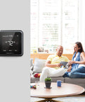 Renewed T5 Plus Smart Thermostat Black with 7 Day Scheduling in living room with couple on sofa.