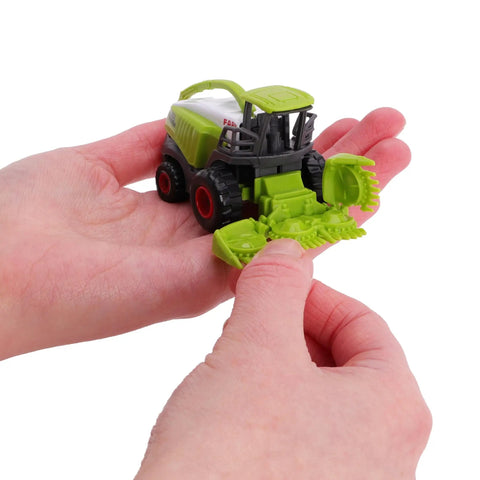 Person holding a green die-cast forage harvester, part of a Five Piece Green Die Cast Farm Machinery Toys Set With Mini Tractors And Harvesters.