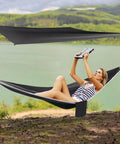 Heavy Duty Camping Hammock With Rain Fly Tarp And Mosquito Net 440 Lb Capacity Portable Tree Hammock set up by a lakeside