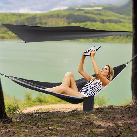 Heavy Duty Camping Hammock With Rain Fly Tarp And Mosquito Net 440 Lb Capacity Portable Tree Hammock set up by a lakeside