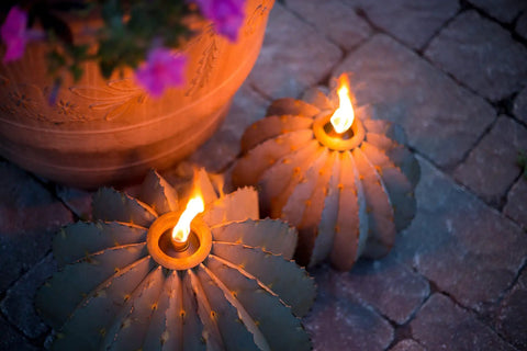 Golden Barrel Cactus Torch Outdoor Yard Art In Weatherproof Steel Large 18 Inch Wide By 13 Inch High Lawn Decor That Burns For 4 To 6 Hours Southwestern Desert Tiki Light For Backyard Vibes shown burning on a stone patio.