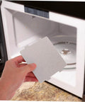 Hand holding Microwave Waveguide Cover Mica Sheet Replacement For Ovens With High Heat Resistance And Insulation Board in front of microwave.