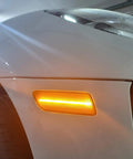 Close-up of Smoked Lens Full LED Front Side Marker Kit for Porsche Macan 2014-2024, Amber Sidemarker Lights installed, illuminated view.