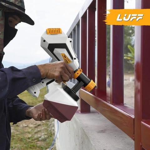 Heavy Duty 700W HVLP Electric Paint Sprayer Featuring A Roomy 1200ml Tank And Five Brass Nozzles With Three Adjustable Patterns For No Sweat Furniture Fence And Wall Finishes, in use on a red fence.