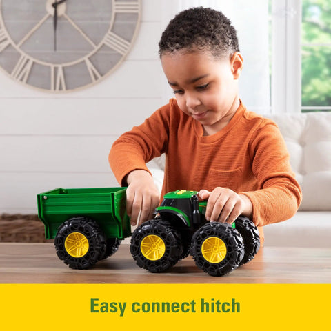 Child playing with Rad Monster Treads Tractor Toy with Wagon Lights and Sounds Monster Truck Tire Action John Deere Farm Playset