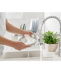 User rinsing a soapy dish under Smooth Operator Pull Down Kitchen Faucet With Brushed Nickel Finish Single Handle Control 360 Degree Swivel Spout Two Mode Spray Head For Dang Fast Cleanup And Killer Build Quality.