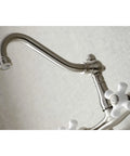 Close-up of Old School Vintage Style Wall Mount Kitchen Faucet in Brushed Nickel, Swivel Victorian Spout, white handles visible