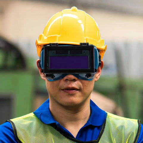Slick Auto Darkening Welding Goggles With Flip Up Lens And Anti Scratch Shield worn by a worker in safety gear for welding.