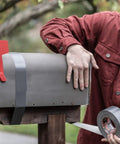 Applying Ferociously Strong Duct Tape 105 Yards Triple Pack Gunmetal Gray to fix metal mailbox outdoors, showing premium adhesive.