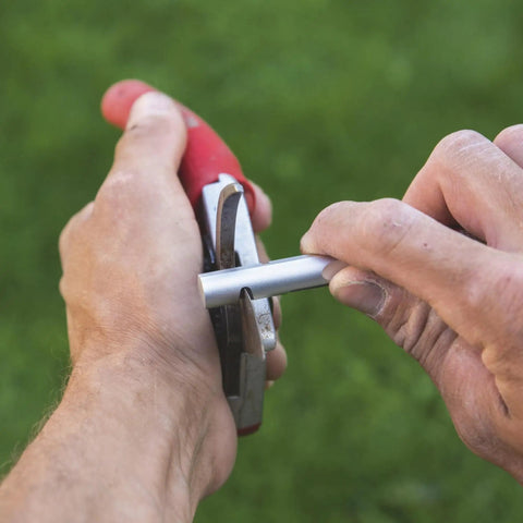 Hands using Model 905 Sharpener Carbide Stone For Pruning Shears Pro Grade Honing And Sharpening Tool on shears outside