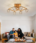 Farmhouse Chandelier With Orb Glass Globes And Oak Finish 6 Light Totally Rustic Vintage Pendant Light Fixture For Kitchen Island Dining Room Living Room Foyer And Entryway UL Listed against a living room ceiling, showing warm illumination over a family on a couch.