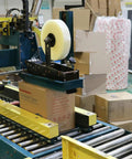 No Frills Clear Packing Tape Two Point Five Mil Thick One Point Eight Eight Inches Wide Six Pack functioning on a packaging machine.