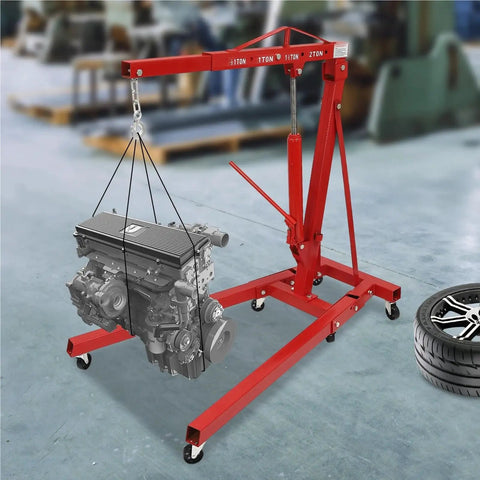 Professional Grade Heavy Duty Two Ton Hydraulic Engine Hoist Folding Cherry Picker Shop Crane lifting an engine in a garage.