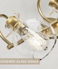 Two-Light Gold Bathroom Vanity Light Fixture With Clear Globe Shades, close-up showing bulb close to globe, E26 base detail