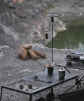 Collapsible Lantern Stand For Camping And Backyard set up on a campsite table with aluminum hook holding a small lantern