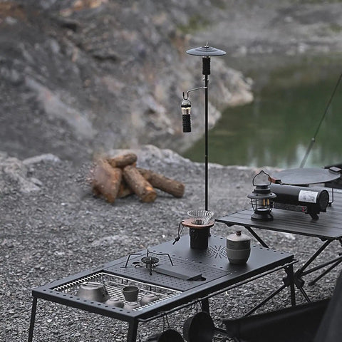 Collapsible Lantern Stand For Camping And Backyard set up on a campsite table with aluminum hook holding a small lantern