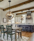 Rustic 4 Light Orb Chandelier Handcrafted From Solid Wood With Black Metal Details Ideal For Dining Room Kitchen Island Hallway Or Entryway Delivers Cozy Warm Farmhouse Glow And Modern Farmhouse Charm hanging over a dining table in a rustic kitchen setting