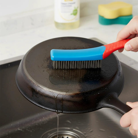 Person using Rust Removal Wire Brush With Ergonomic Handle, Stainless Steel 8-Row Metal Scrubber, on metal skillet.