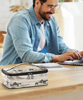 Desert Cowboys Insulated Lunch Bag With Leakproof Cooler Portable on a table, man working on laptop in the background