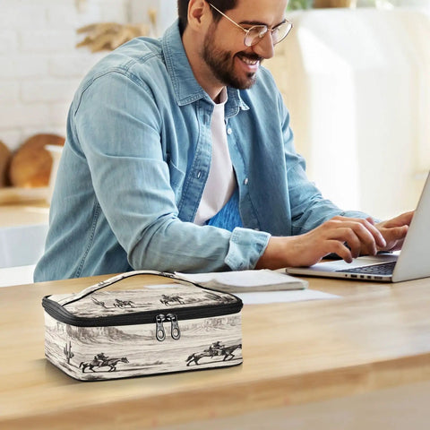 Desert Cowboys Insulated Lunch Bag With Leakproof Cooler Portable on a table, man working on laptop in the background