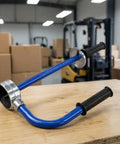 No Sweat Packing Heavy Duty Manual Stretch Film Dispenser Ergonomic Handheld Pallet Wrap Tool with knuckle saving grips on a wooden table.