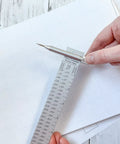 No Fuss Aluminum Beam Compass Ruler Kit With Adjustable Trammel Points and Precision Leads on graph paper.
