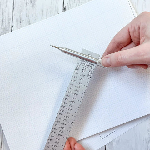 No Fuss Aluminum Beam Compass Ruler Kit With Adjustable Trammel Points and Precision Leads on graph paper.
