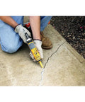 Using Concrete Crack Filler And Sealer Ready To Use 10 Oz Tube That Is DIY Friendly Sanded Acrylic Formula on a driveway crack.