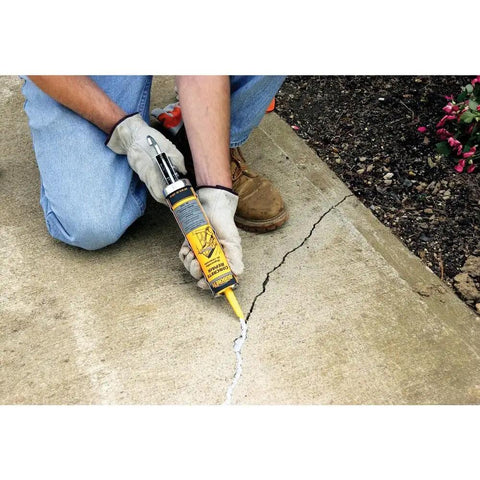 Using Concrete Crack Filler And Sealer Ready To Use 10 Oz Tube That Is DIY Friendly Sanded Acrylic Formula on a driveway crack.