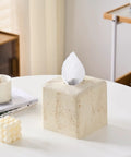 Heavy Resin Tissue Box Cover With Travertine Texture For Home Decor on a white tabletop with coffee cup and books.