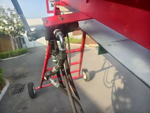 Close-up of hydraulic controls and wheels on 7HP Gas Powered Firewood Conveyor 18FT Long Log Conveyor With Hydraulic Adjustable Height And PVC Anti Slip Belt Portable Timber Elevator With Trailer Hitch And Tires For Farm Home And Commercial Use.