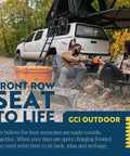 Two people sitting in Kickback Rocker Outdoor Low Profile Rocking Chairs with Cup Holders and Portable Carry Straps at a campsite.