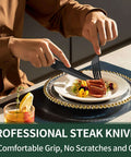 Person using black flatware set for 4 with steak knives from 24 piece stainless steel cutlery on elegant dinner plate