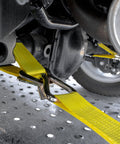 Close-up of Complete Axle Strap Tie Down Kit With Wire Hook Ratchet Straps In Classic Yellow securing car axle on trailer.