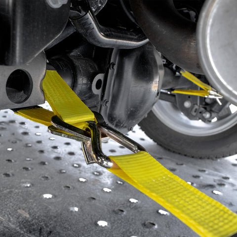 Close-up of Complete Axle Strap Tie Down Kit With Wire Hook Ratchet Straps In Classic Yellow securing car axle on trailer.