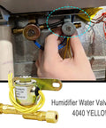 Installed view of humidifier water solenoid valve 4040; yellow unit with brass fittings and yellow wires, 24V 2.3W.