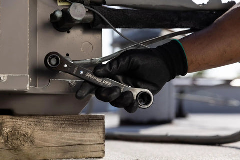 Hand using 8-In-1 SAE Ratcheting Wrench Set In Two Pieces With Hollow Sockets And Double Box End Design Includes 5/16 3/8 7/16 9/16 5/8 11/16 3/4 Inch 12 Point Ratchet Heat Treated For Durability Made In USA on machinery