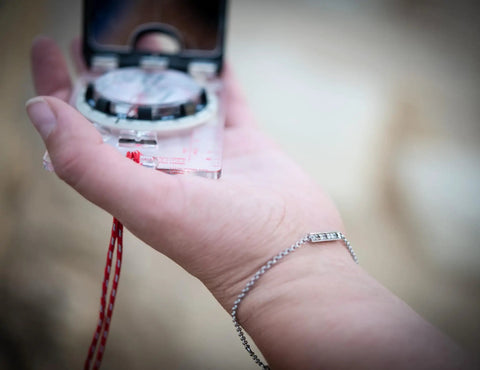 Hand holding Advanced Mirror Compass For Pros And Serious Hikers With Metric UTM Scales And Inch Ruler, open with mirror visible