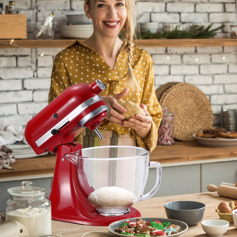 Red stand mixer with glass bowl in cozy kitchen setting