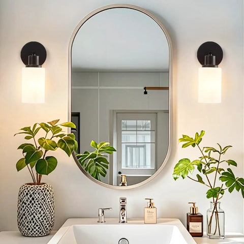 Farmhouse Style 2 Light Wall Vanity Light Fixture With Glass Shades in bathroom with mirror above sink, matte black metal