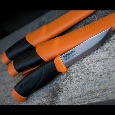 Heavy Duty Outdoor Knife With A 4.1-Inch Stainless Steel Blade And Bright Orange Handle, displayed on a wooden surface