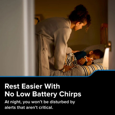 Parent tucking child into bed at night, promoting smart carbon monoxide detector's silent battery feature, ensuring restful sleep.