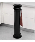 Ultra Heavy Duty Floor Standing Espresso Knock Box For Commercial Shops And Home Bars Hella Rock Solid Build Three Piece Snap Fit Design Super Fast Coffee Grounds Cleanup in black with towel holder.