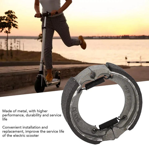 Electric Scooter Front Drum Brake Pad Shoe Replacement Part Built Tough From Lightweight Metal For Smooth Stops And Long Lasting Performance Easy Install Compatible With Most 8 And 9 Inch Models shown with scooter in background.