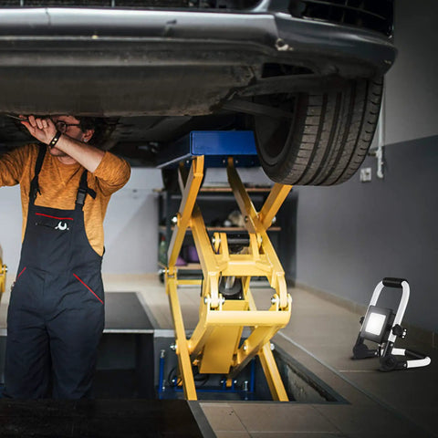 Garage scene with mechanic using 3000 Lumen LED Work Light With Adjustable Stand, Portable Flood Light for car care