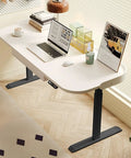 Rock Solid Electric Sit Stand Desk With Memory Height Presets And Cargo Pullout Bin Using Buttery Smooth Lift Motor Plus Leather Guard Edge For Zero Sweat Home Office Setup At 55 Inches Wide, viewed from above with laptop and decorative items.