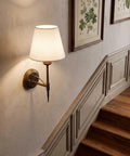 YS.ESUDSI Vintage Wall Sconces with White Fabric Shade Hardwired E26 Base mounted on a wall beside a staircase.